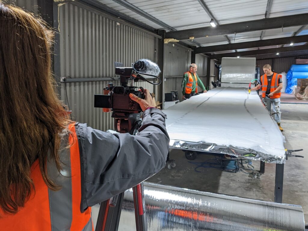 filming two SuperFOIL employees creating a roll of multifoil insulation